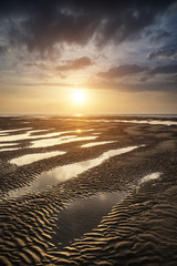 Beautiful vibrant Summer sunset over golden beach landscape