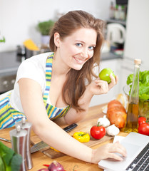 Frau mit Laptop in der Küche 