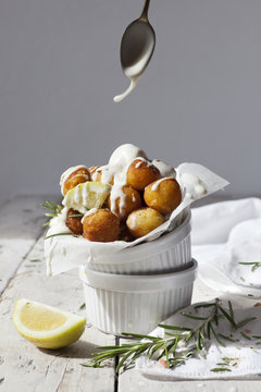 balls of fried potatoes with dripping yogurt sauce from spoon