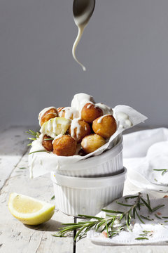 balls of fried potatoes with dripping yogurt sauce from spoon