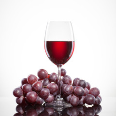 Glass of red wine and grape isolated on white