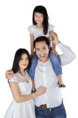 Joyful family smiling at camera in studio