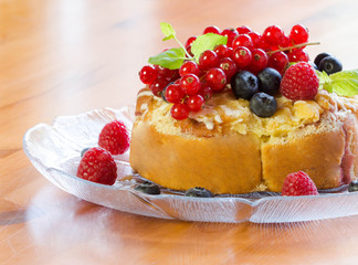 A cake with berries, red currants and fresh mint