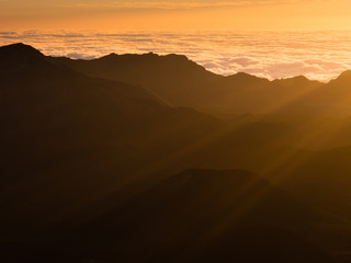 Fototapeta na wymiar Beams of the rising sun over Haleakala volcanic crater on Maui