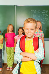 Fototapeta na wymiar Boy stands in front of kids near blackboard