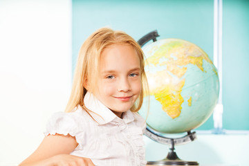 Blond girl portrait with globe and blackboard