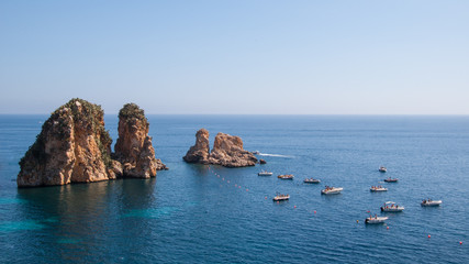 Tourist boats next to cliffs on a calm mediterranean sea