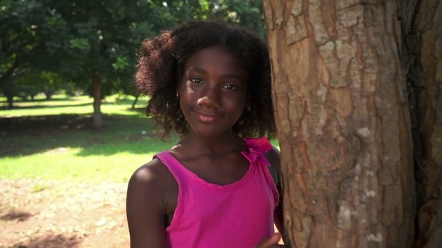 2of18 Black school girl hugging tree in park, ecology