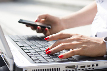 Fototapeta premium Hands of a businesswoman typing on a computer keyboard