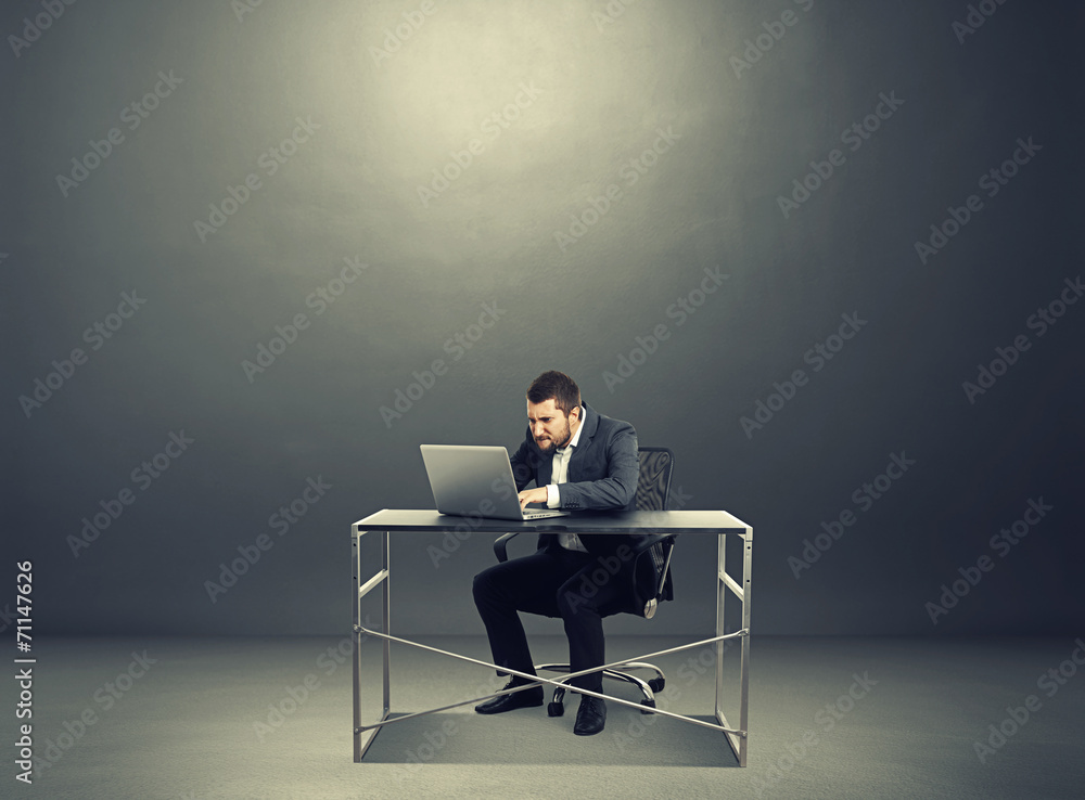 Wall mural man working with laptop over dark