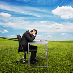 sad man sitting at the table with laptop