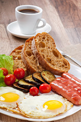 English breakfast - fried eggs, sausages, eggplant and tomatoes