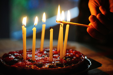 anniversary cake with l burning candles in dark