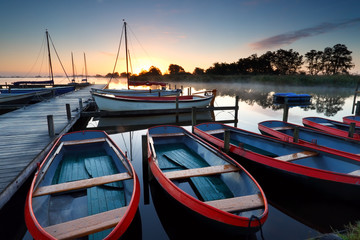 boats and yachts on lake at sunrise