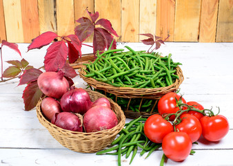 basket of green beans with tomatoes and onions