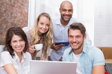 Fototapeta premium Business people looking at camera behind a laptop