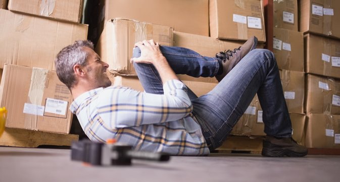 Worker Lying On The Floor In Warehouse