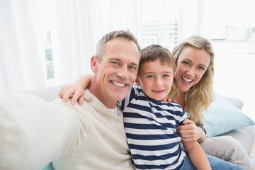 Obraz premium Portrait of a smiling family sitting on sofa