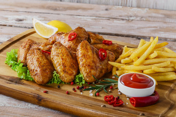 fried chicken wings with red sauce and French fries