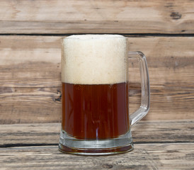 Mug of beer close up on wooden table