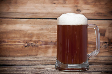 Mug of beer close up on wooden table