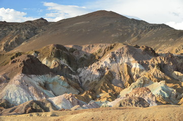 Stone brown peaks directed to the blue sky among the hot desert