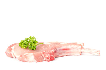 Raw pork chops and parsley on white background