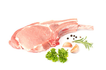 Raw pork chops and vegetables on white background