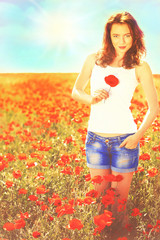 Naklejka na ściany i meble Beautiful young woman in poppy field