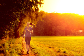 Junge Frau geht im Sonnenaufgang joggen