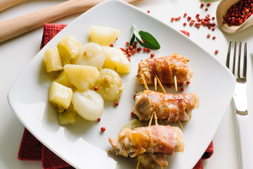 Bacon rolls, chicken, cheese with potatoes and onions