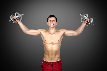 Sexy muscular man lifting dumbbells