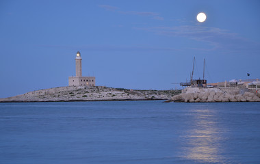 Twilight over a lighthouse in Vieste town, Italy