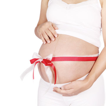 Belly of a pregnant woman with red and white ribbon