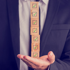 Businessman holding a stack of checked boxes