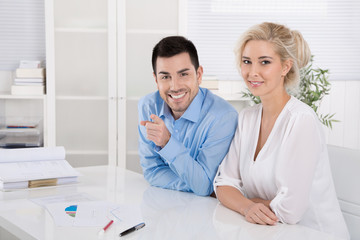 Fototapeta premium Junge Hochschulabsolventen sitzend im Büro: Mann u. Frau