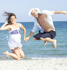 Happy couple jumping on the beach