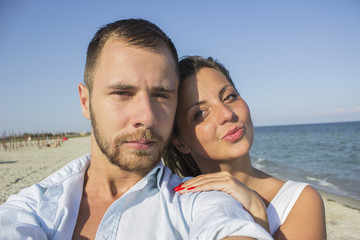 Happy couple taking a photo on a beach