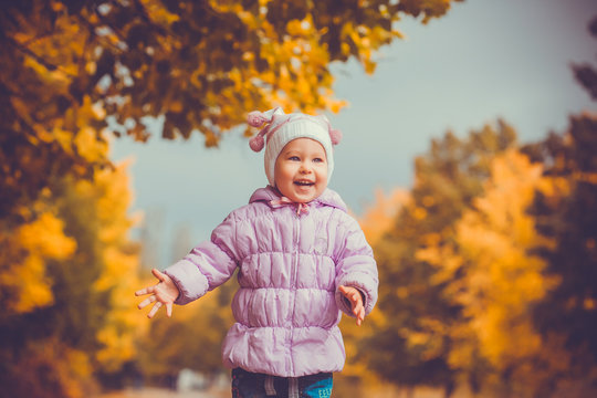 happy playful baby in the autumn park