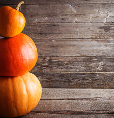 three pumpkins on wooden background