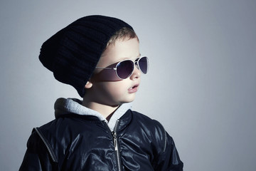 Fashionable little boy in sunglasses.Child in Black cap.Winter