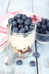 Natural yogurt with fresh blueberries on wooden table