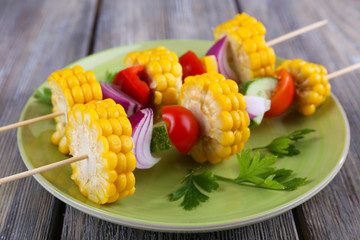 Sliced vegetables on wooden picks on plate on table close-up