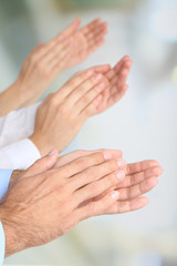 Clapping hands on bright background