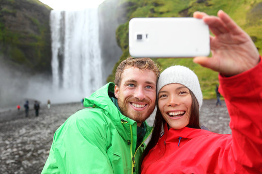 Selfie couple taking smartphone picture waterfall