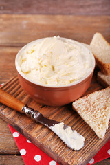 Fresh homemade butter in bowl and sliced bread,