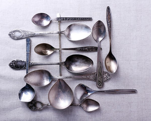 Metal spoons on fabric background