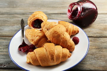 Breakfast with fresh croissants on wooden background