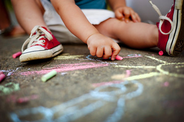 Close up of boy drawing with chalks