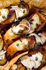 Toasts with grilled eggplant, mozzarella cheese and capers